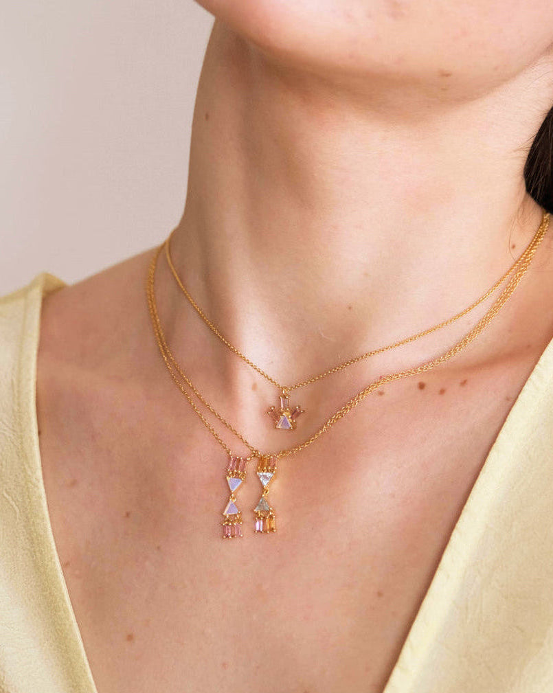 Model wearing the Atlante opal V necklace and the blue topaz one with the pyramid ray opal necklace