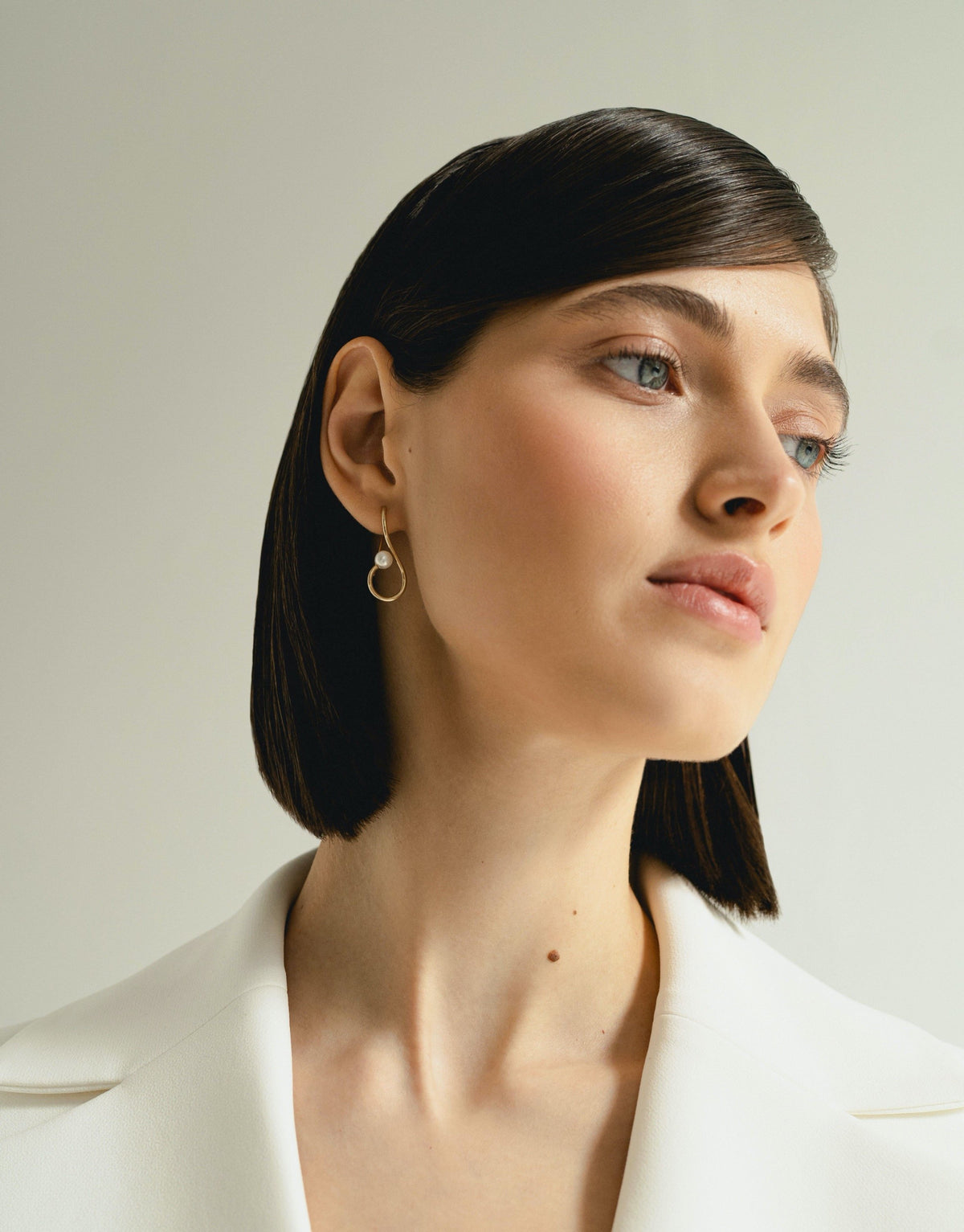 Infinity Earrings in 9k yellow gold with a round pearl by Nayestones, Belgian fine jewelry.