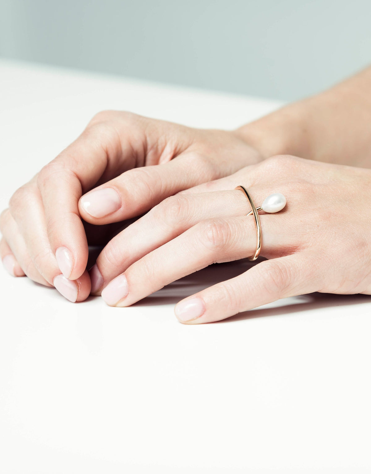 Julia Double ring in 9K yellow gold with a pearl between the fingers by Nayestones, Belgian fine jewelry.