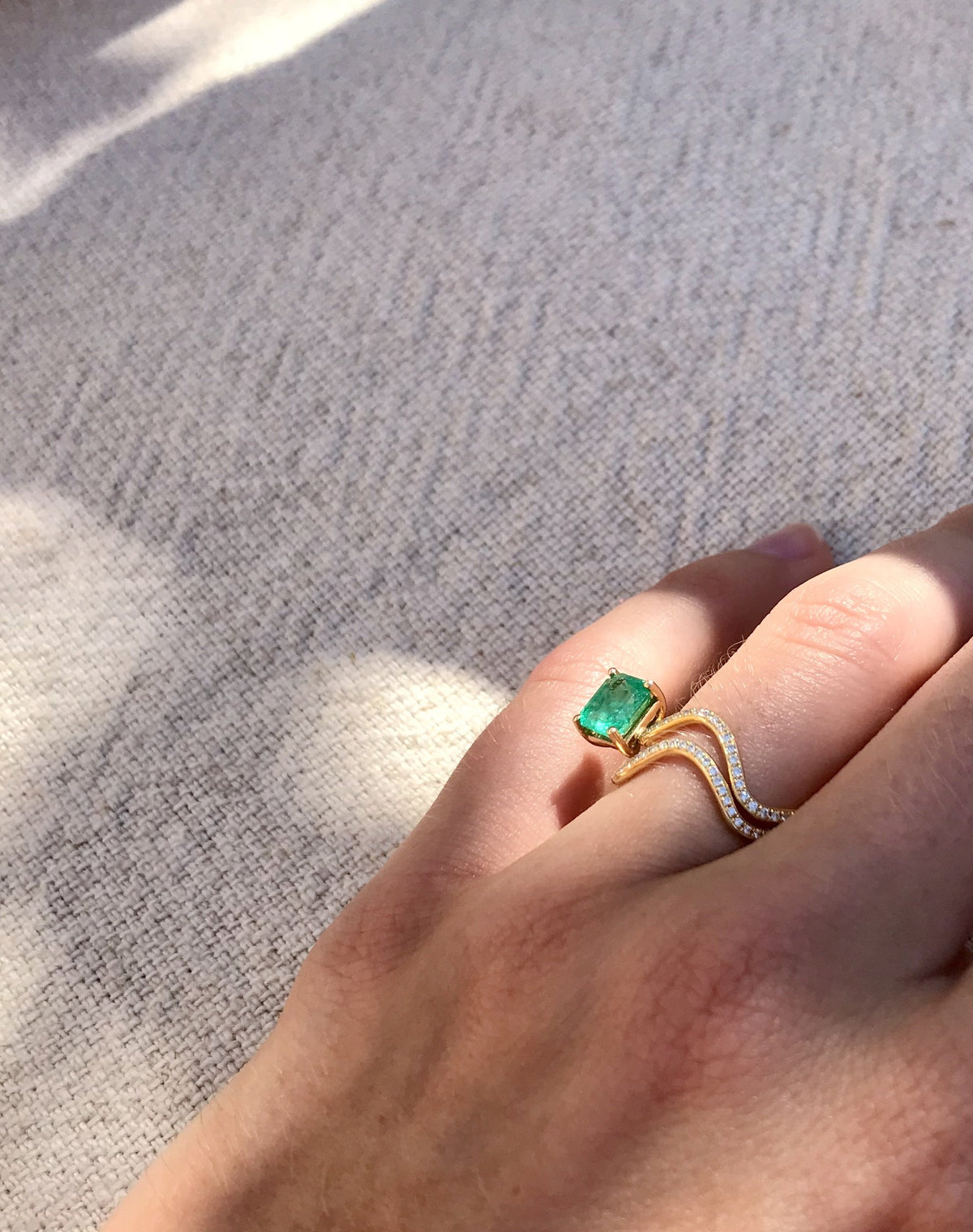 Petite Cométe ring in 18K yellow gold with diamond pavé and baguette emerald by Nayestones. Belgian fine jewelry.