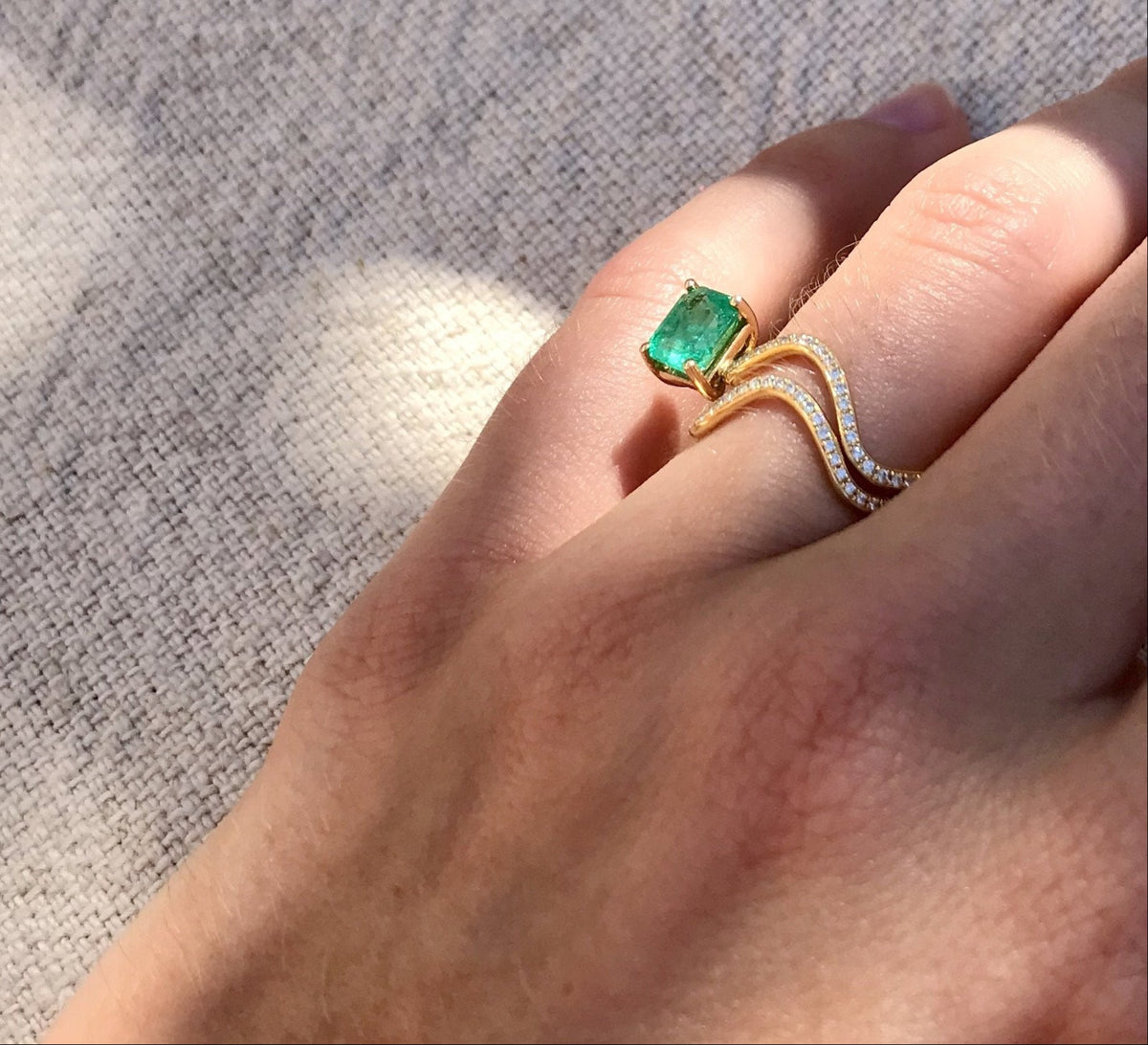 Petite Cométe ring in 18K yellow gold with diamond pavé and baguette emerald by Nayestones. Belgian fine jewelry.