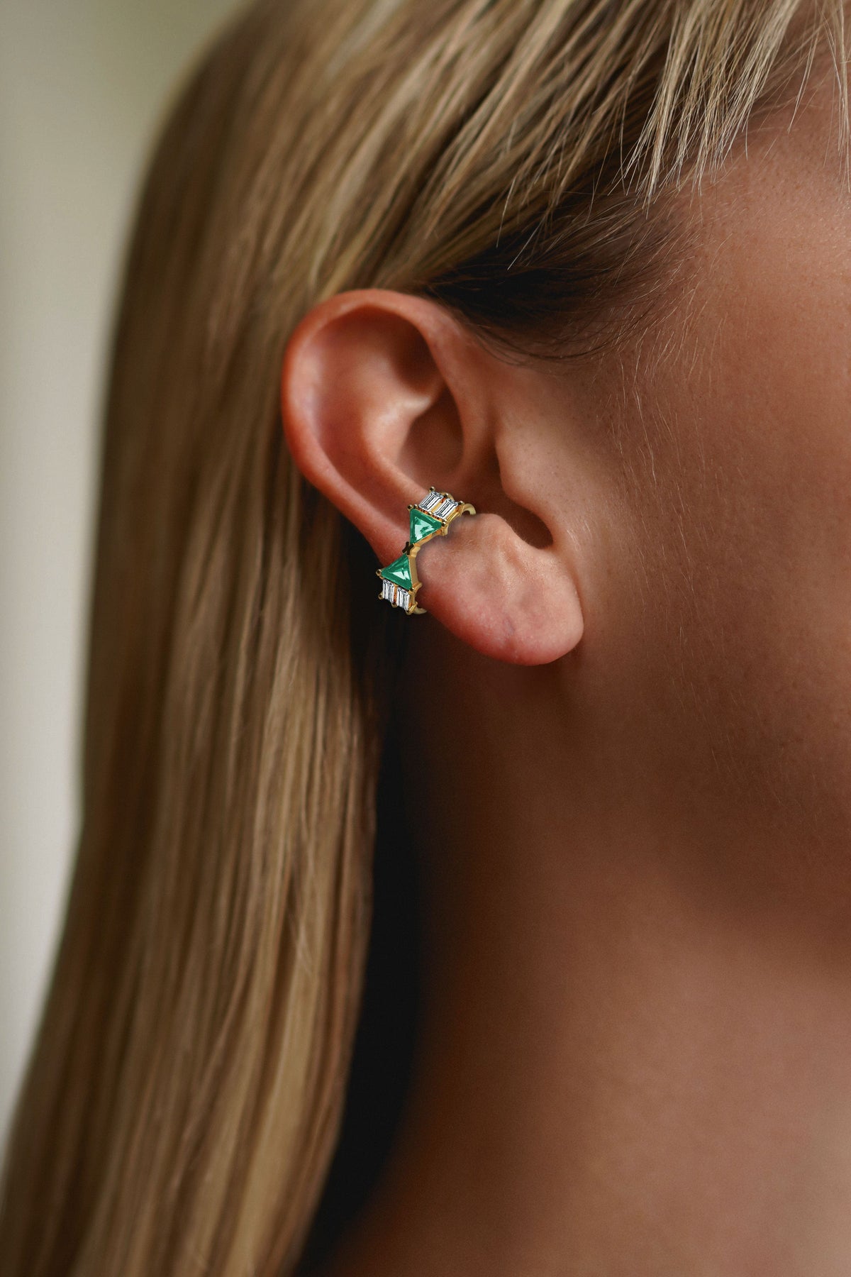 Alante Ear Cuff in 18k yellow gold and 2 trillion-cut emerald stones and 4 baguette-cut diamond by Nayestones, Belgian Fine Jewelry. 