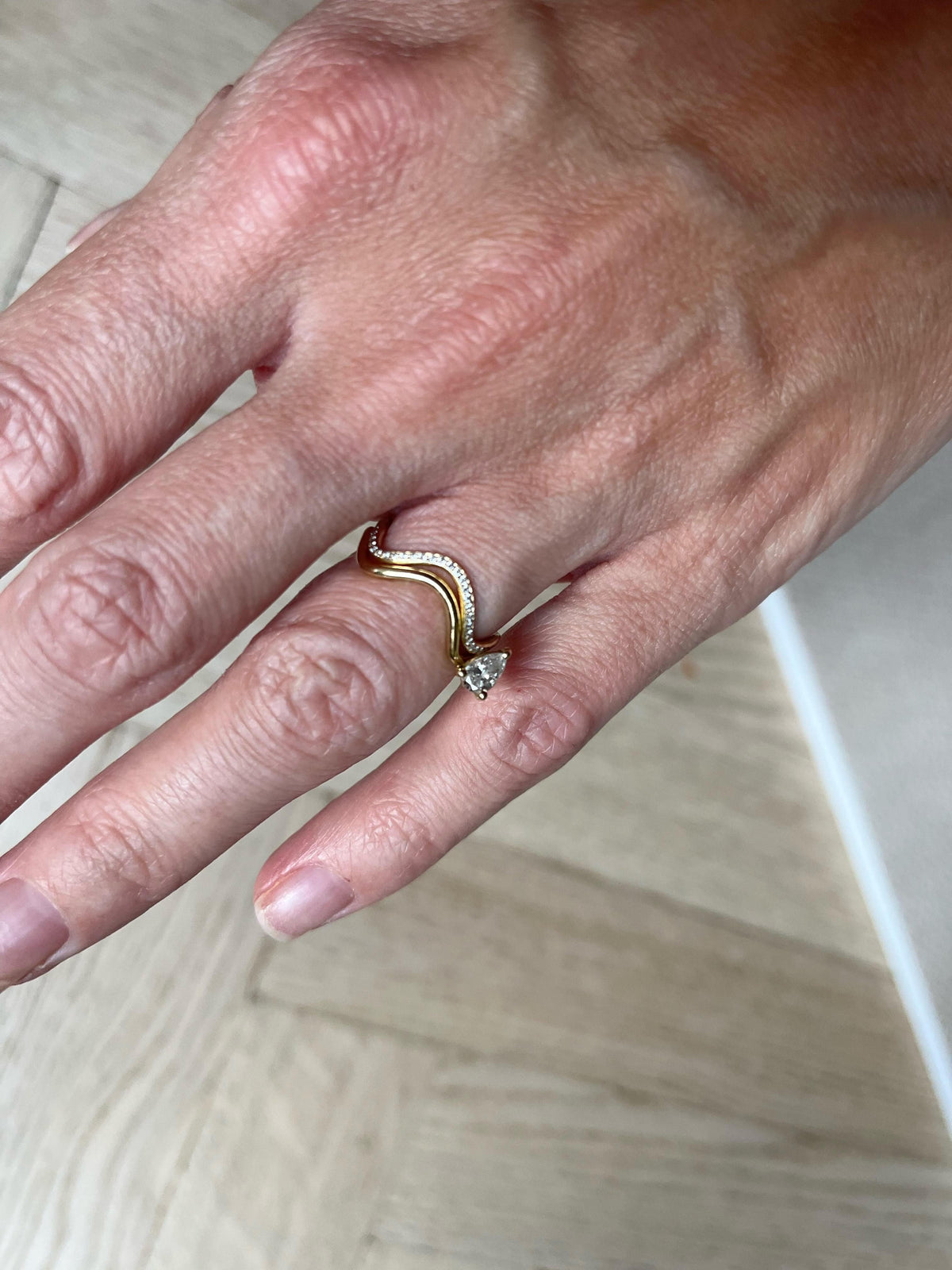Petite Comète ring in 18k yellow gold with a pear-shaped diamond by Nayestones, Belgian fine jewelry.