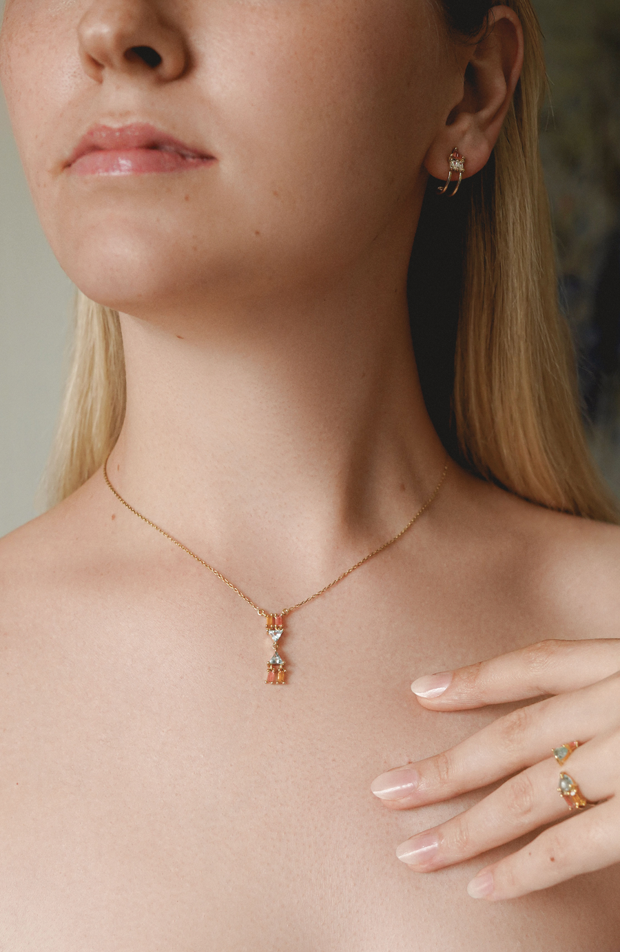 on body of Atlante Gold Necklace Featuring 2 opal triangle stones with 4 light pink tourmaline baguettes 