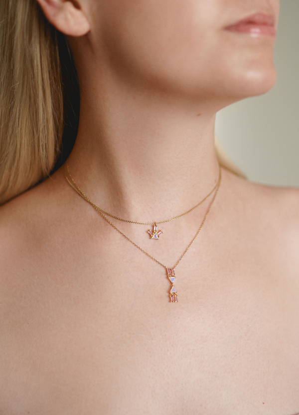 Displaying a stack of two Pyramid Ray Necklaces from Nayestones crafted in 18-karat recycled gold, showcasing a light blue topaz, two citrines, and a single pink tourmaline baguette