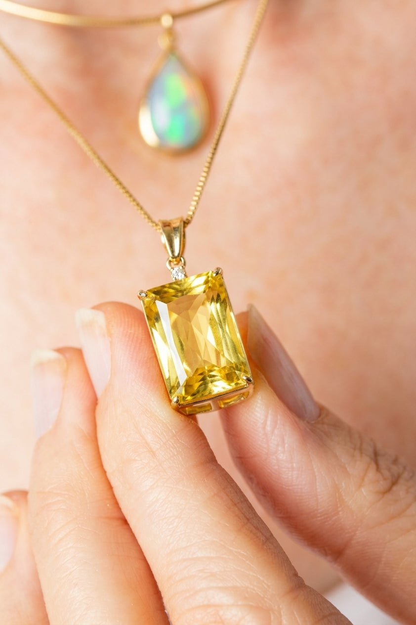 Model wearing the Gourmette Chain in 18K sustainable yellow gold, paired with the Gemora Pendant featuring an emerald-cut yellow quartz and diamond-encrusted bail.
