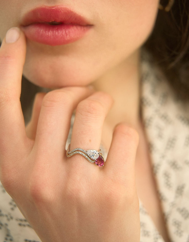 Petite Comète engagement rings in 18K white gold ring with a 0.25-carat Pear Star Diamond and a Pear Pink Tourmaline, with pavé diamonds by Nayestones on the model's hand. Nayestones