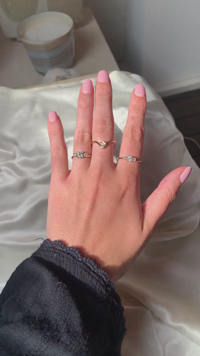 Hand wearing a 0.50 ct and a 0.75 ct trilogy engagement ring, heart ring, by Nayestones, Belgian fine jewelry.