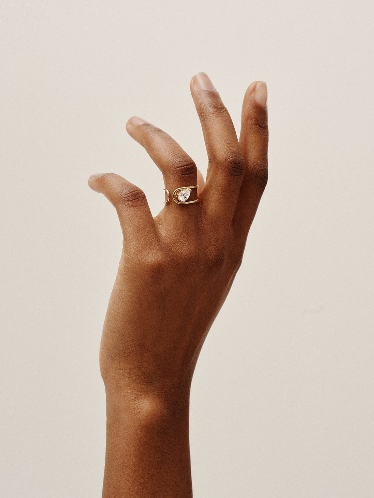 Double C Ring in 18K yellow gold with a pear-cut diamond by Nayestones, Belgian fine jewelry. 