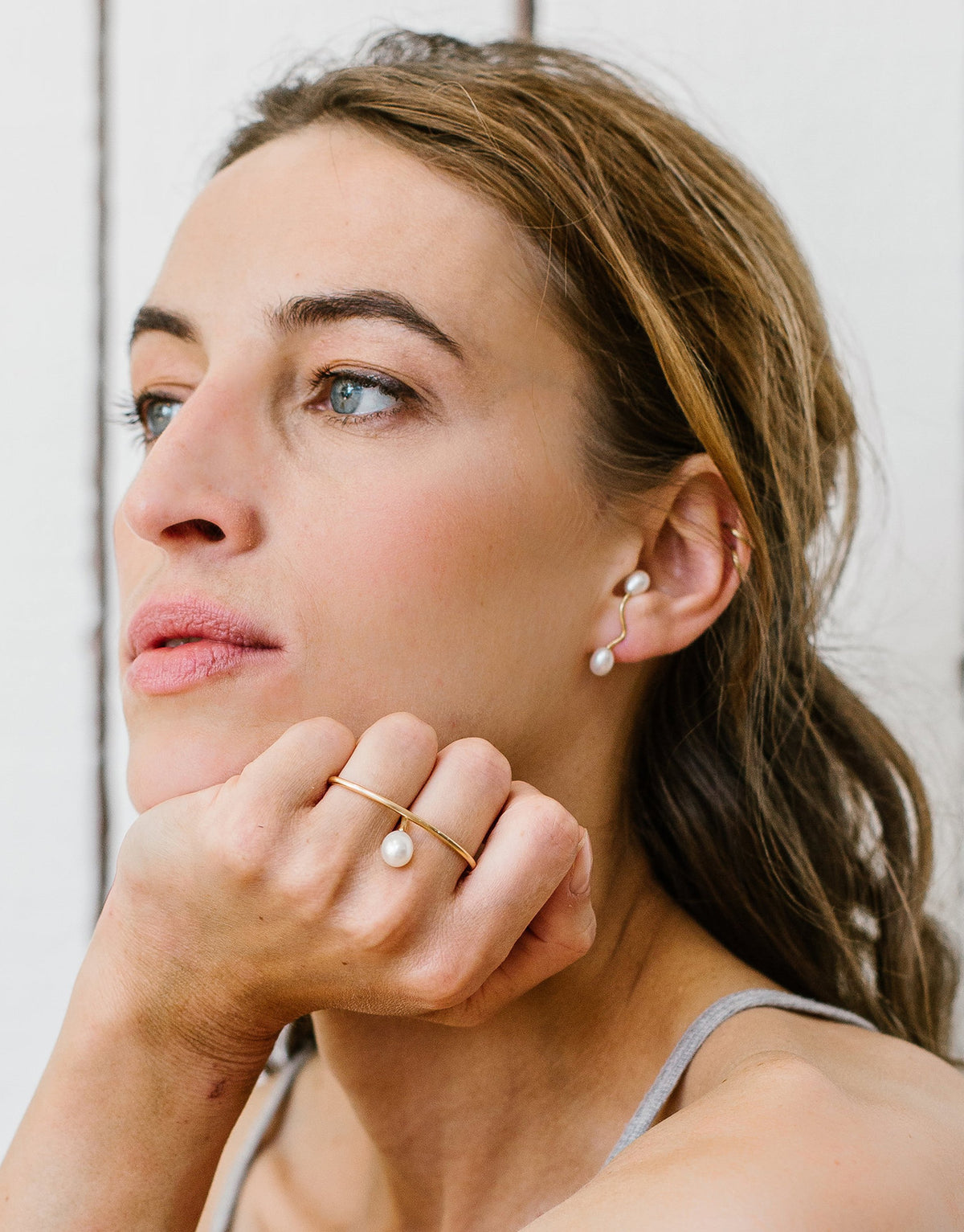 Julia Double ring in 9K yellow gold with a pearl between the fingers by Nayestones, Belgian fine jewelry.