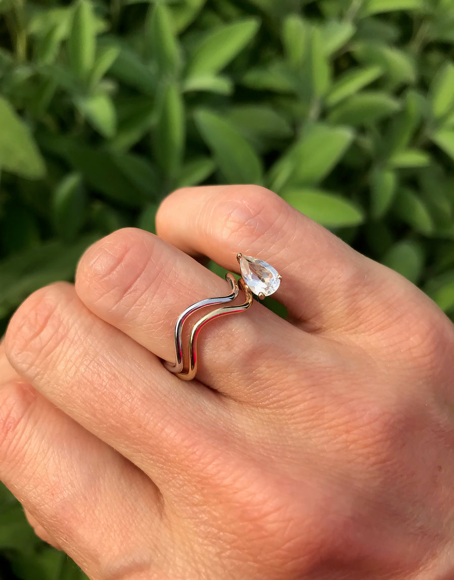 Stacked rings from Nayestones' Petite Comète Collection: one simple band paired with a White Topaz Pear-Cut adorned ring