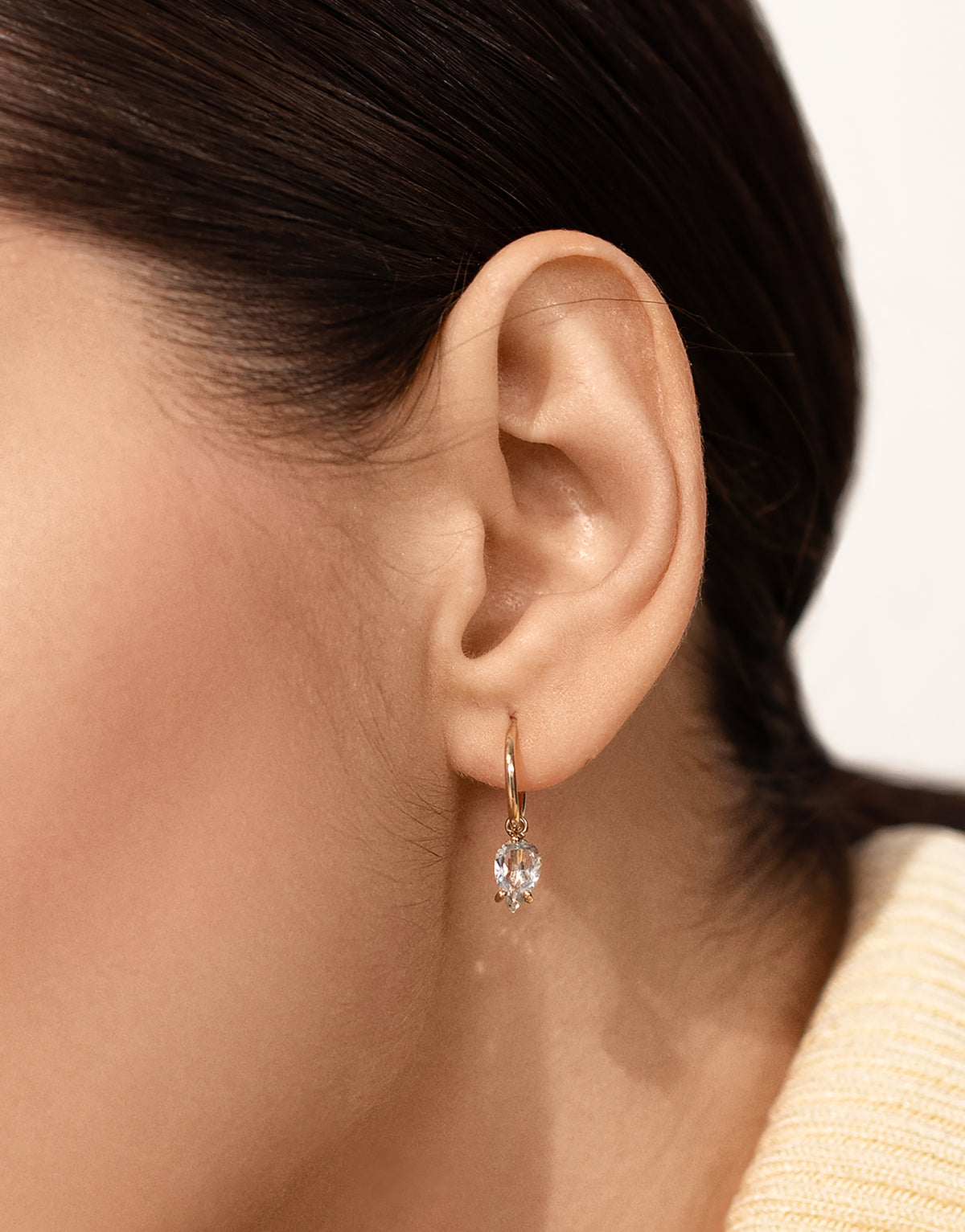Bloom petite creole earring in 9K yellow gold with an pear cut topaz by Nayestones, Belgian Fine Jewelry. 